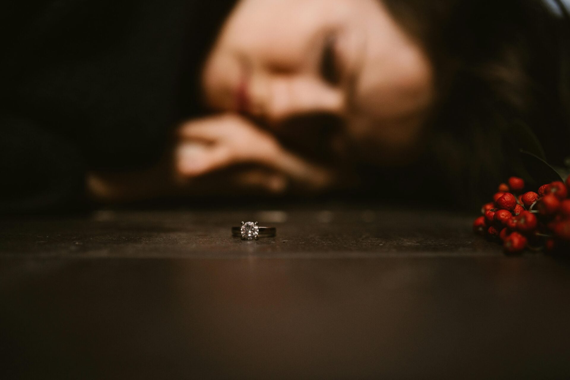 Woman crying with an engagement ring, symbolizing heartbreak and betrayal